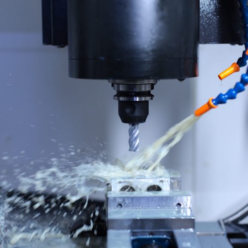 Metalworking CNC milling machine. Cutting metal modern processin Fresatura con lubrorefrigerante e trucioli: raffreddamento efficace per ridurre usura e scarti.